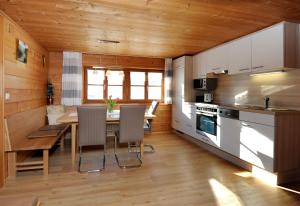 eine Küche mit einem Tisch und Stühlen im Zimmer in der Unterkunft Ferienwohnungen Moosbrugger in Au im Bregenzerwald