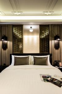 a bedroom with a large white bed with two pillows at De Chai the Deco Chiang Mai - SHA Plus in Chiang Mai
