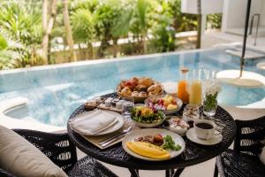 a table with food on it next to a pool at The Seven Stars Resort in Ishigaki Island