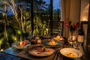a table topped with plates of food and wine at The Seven Stars Resort in Ishigaki Island