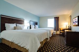 a hotel room with two beds and two lamps at Best Way Inn Cleburne in Cleburne