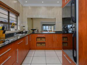 a large kitchen with wooden cabinets and a sink at Seagull Villa in Margate
