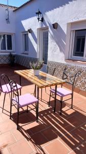 a wooden table and chairs on a patio at El Molinero in Monesterio