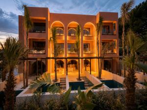 an exterior view of a building with palm trees at Palmea Suites in Pefki