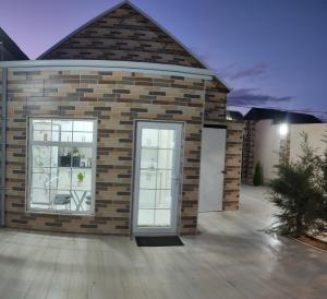 a brick house with a large glass door at Beach House Buzovna in Baku