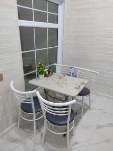 a white table and chairs with a window at Beach House Buzovna in Baku