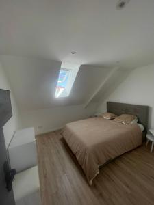 a bedroom with a bed in a attic with a window at herseaux in Mouscron