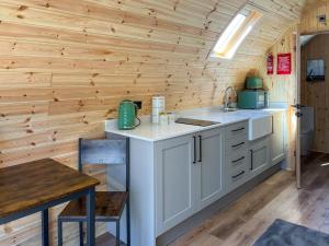 a kitchen with white cabinets and a wooden wall at Birch - Uk51862 in Reighton