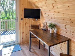 a wooden table in a room with a tv on a wall at Birch - Uk51862 in Reighton