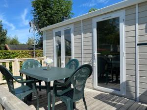 a table and chairs on the deck of a holiday house at Camping Les 2 Plages in Quend