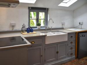 a large kitchen with a sink and a window at Mark's Cottage in North Walsham