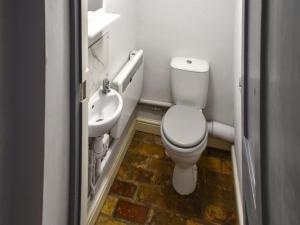 a small bathroom with a toilet and a sink at Mark's Cottage in North Walsham +4 photos