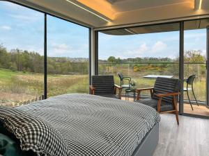 a bedroom with a bed and chairs and a large window at Vessel 1 - Ukc9441 in Glasgow