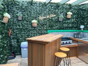 a green wall with a bar and stools in a kitchen at Vessel 1 - Ukc9441 in Glasgow