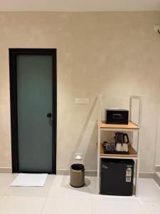a door leading into a room with a microwave at NestSort Hotel in Mysore