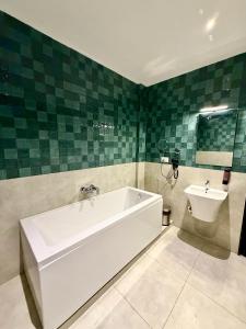 a bathroom with a white bath tub and a sink at NestSort Hotel in Mysore +23 photos