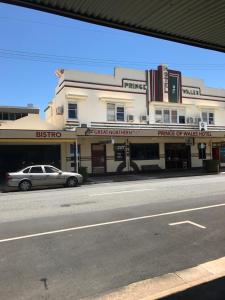 a building on a street with a car parked in front at The Prince of Wales in Proserpine