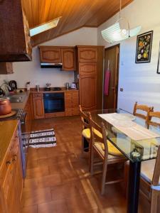 a kitchen with a glass table and wooden cabinets at Casa Dolce Casa in Tirano