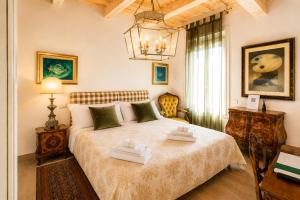 a bedroom with a bed and a chandelier at Al Battistero Luxury Suite in Ravenna