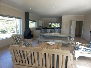 a living room with a wooden table and chairs at Ripples Beach House - 14 sleeper in Port Alfred