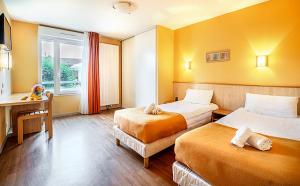 a hotel room with two beds and a desk at Azureva Club Métabief in Métabief