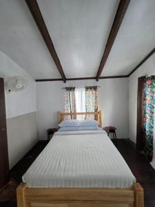ein großes Bett in einem Zimmer mit zwei Fenstern in der Unterkunft Pula Re Accomodation in Savusavu