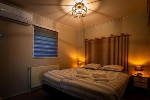 a bedroom with a large bed with a ceiling fan at Dopheide: In Drenthe spheres (4p) in Erm +73 photos