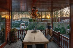 a wooden deck with a wooden table on a patio at Dopheide: In Drenthe spheres (4p) in Erm