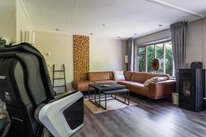 a living room with a couch and a tv at Dopheide: In Drenthe spheres (4p) in Erm