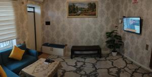 a living room with a blue couch and a table at Beach House Buzovna in Baku