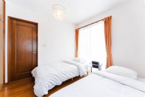 a bedroom with two beds and a chandelier at Gunkanjima 307 in Nagasaki