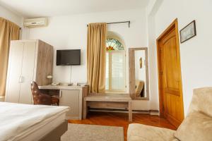 a bedroom with a bed and a desk and a window at Vila Belvedere in Galaţi