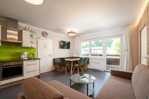 a kitchen and living room with a couch and a table at ''die Bergerin'' | Appartements Schladming in Schladming +182 photos
