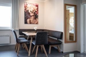 a dining room with a table and chairs and a painting at ''die Bergerin'' | Appartements Schladming in Schladming