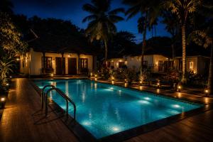 a swimming pool in front of a house at night at Winterfeel Venice Resort By Neon Nest in Alleppey