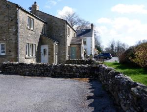 a brick house with a stone wall in front of it at 2 Rock View in Settle