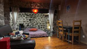 a living room with a bed and a stone wall at Votre cocon en Ardèche Verte in Saint-Prix