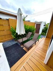 a patio with two chairs and an umbrella at The Town Pool Villas in Krabi