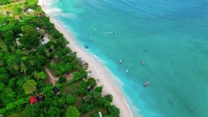 an aerial view of a beach with boats in the water at Kaia Raya Surf Lodge in Maluk