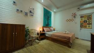 a bedroom with a bed and a chair in it at Côn Đảo Home in Con Dao