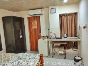 a room with a kitchen with a desk and a refrigerator at Ebony Room - AC, Kitchenette, Ensuite, Independent Homestay in Mumbai +35 photos
