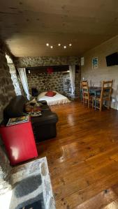 a living room with a couch and a bed and a table at Votre cocon en Ardèche Verte in Saint-Prix