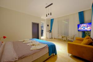 a bedroom with a bed and a couch and a television at EDEN NEST EXCLUSIVE HOTEL in Belek