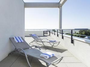 two chairs and towels sitting on a balcony at Novotel Suites Nice Airport in Nice