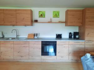 a kitchen with wooden cabinets and a stove at Ferienwohnung Mutzenbauer in Bad Endorf