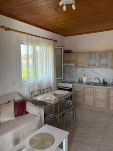 a living room with a couch and a table and a kitchen at Lemon tree apartment in Kyllini