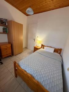 a bedroom with a bed with a blue comforter at Lemon tree apartment in Kyllini