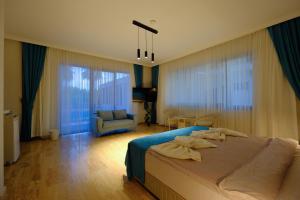 a bedroom with a bed and a chair and windows at EDEN NEST EXCLUSIVE HOTEL in Belek +82 photos