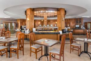 restauracja ze stołami i krzesłami oraz kuchnią w obiekcie Elba Lucía Sport & Suite Hotel w mieście Costa de Antigua