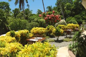 um jardim com mesas, cadeiras e flores em Guindulman Bay Tourist Inn em Guindulman